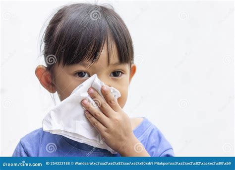 A Little Girl Blowing Her Runny Nose by Tissue Paper. Stock Photo ...