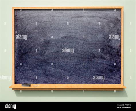 Large wall mounted blank school blackboard or chalkboard with chalk and ...