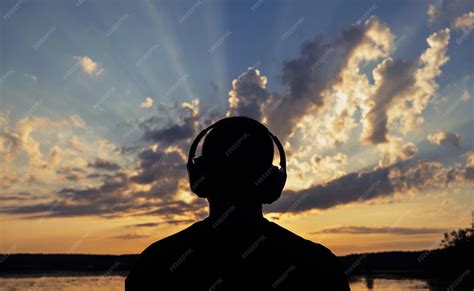 Premium Photo | A man relax listens to calm music looks at the sunset ...