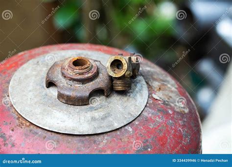 A Broken Gas Cylinder Valve Lies on a Red Cylinder. Danger of Gas Leakage and Explosion. Copy ...