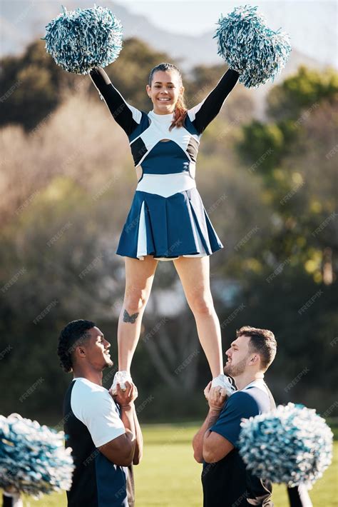 Premium Photo | Cheerleader sports and men balance woman on field for ...