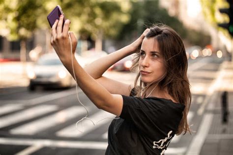 年轻女子用手机拍照图片-女人用手机在大街上自拍素材-高清图片-摄影照片-寻图免费打包下载