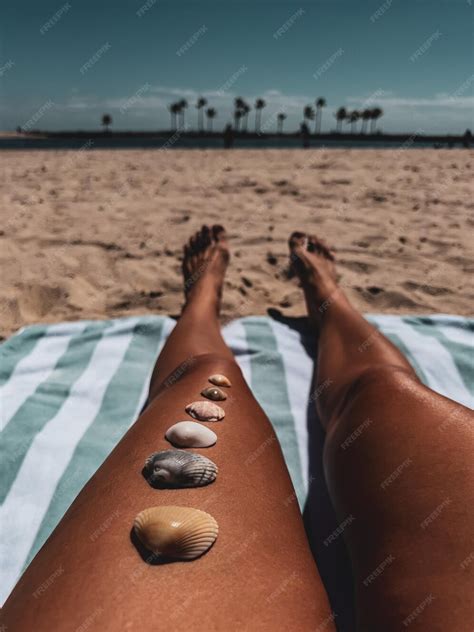 Premium Photo | Girl on the beach seashells lie on a tanned leg weekend ...