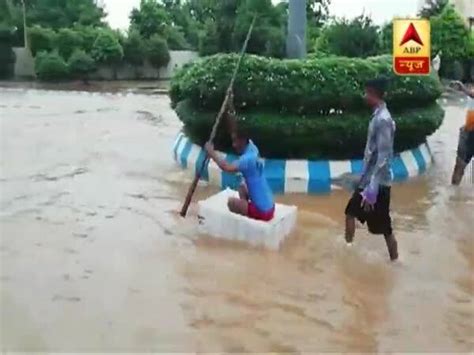 Odisha: Man uses a little boat to cross the street engulfed by rain water