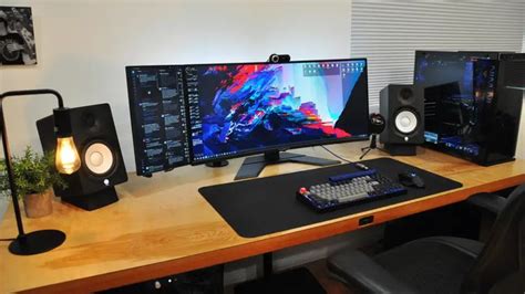 a computer desk with two monitors and speakers