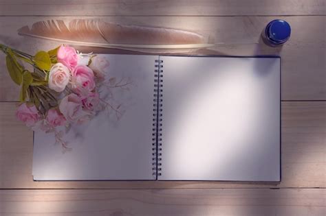 Open note book with feather pen on the wood table | Premium Photo