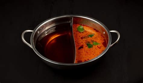 Black water soup & tom yum soup for shabu shabu on a black background ...