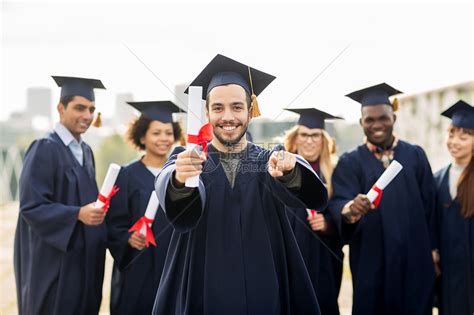 教育毕业人的群快乐的国际学生穿着灰浆板学士服,文凭指向你快乐的学生用文凭指着你高清图片下载-正版图片300411722-摄图网