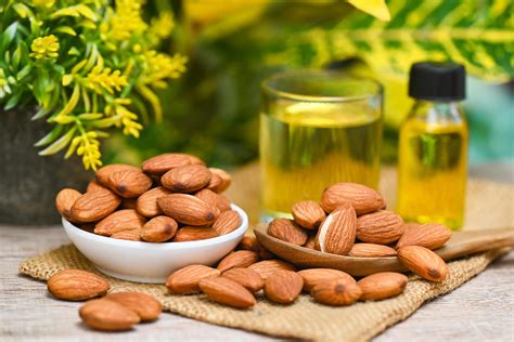 Almond oil and Almonds nuts on bowl plant green nature background ...