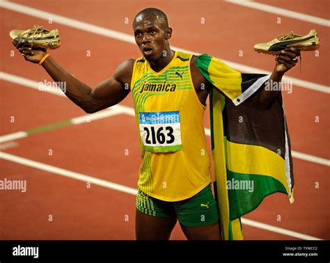 Jamaica's Usain Bolt holds up his golden shoes after setting a world ...