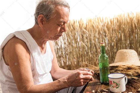 老农民在农田里喝酒高清摄影大图-千库网