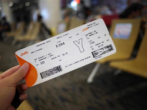 A hand holding Domestic flight boarding pass with blurry airport terminal background 10852224 ...
