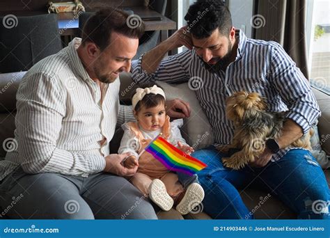 Gay Couple with Their Young Daughter and Dog Sitting on the Sofa ...