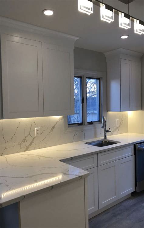White shaker cabinetry with marble look quartz countertops and full ...