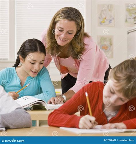 Teacher Helping Student in Classroom Stock Image - Image of helping ...