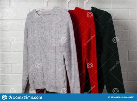 Clothes Hang on Hangers. Sweaters in Red, Green and Melange Colors ...