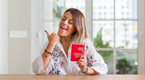 在家中拿着瑞士护照的年轻女子用手和指着高清图片下载-正版图片505418297-摄图网