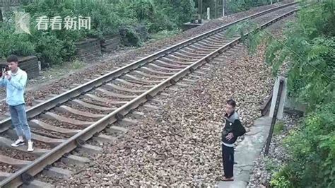 两男子铁轨上与火车玩“创意拍照” 专家提醒当心列车“吸人”