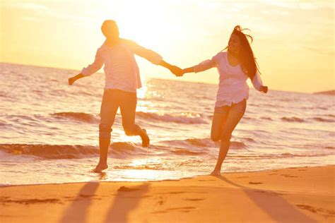 跑步的幸福夫妇图片-拉着手在海边跑步的情侣背影素材-高清图片-摄影照片-寻图免费打包下载