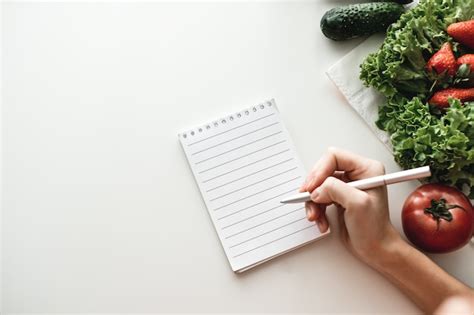 Notebook with pen and vegetables on a table | Premium Photo