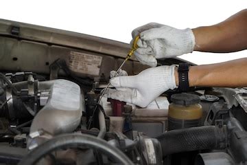 Auto mechanic checking the oil level in car engineinspects engine water ...