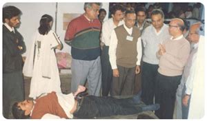 Dr. Devendra Vora demonstrating the use of solar pump. Flanking Dr ...
