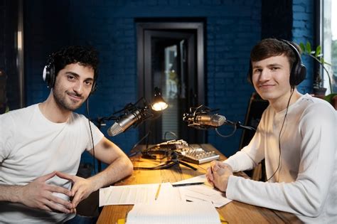 Twee mannen met microfoons en koptelefoon die een podcast draaien ...
