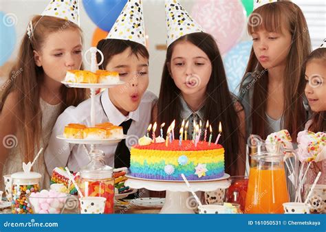 Happy Children Blowing Out Candles on Cake at Birthday Party Stock ...