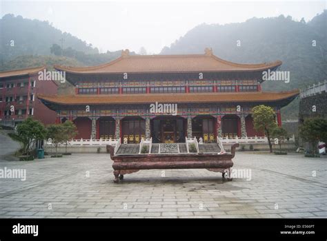 Photo of an elaborate Chinese temple with hedges in front.