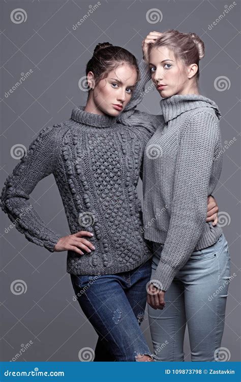 Two Young Women in Gray Sweaters on Grey Background. Beautiful G Stock ...