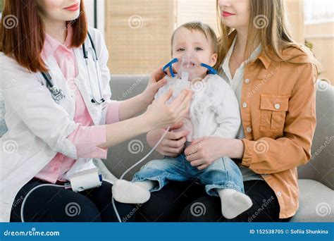 Woman Doctor Hold a Mask Vapor Inhaler for Little Baby Girl . Infant ...