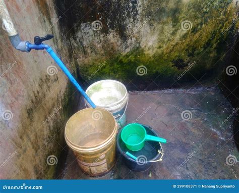 Water Tap and a Group of Buckets Filled with Water in an Old Bathroom ...
