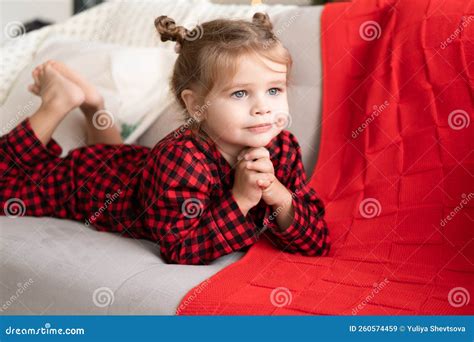 Cute Little Girl in Red Christmas Pajama Smiling Lying on Couch Stock ...