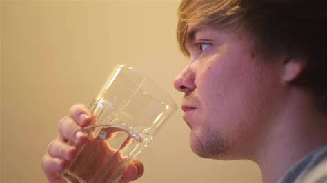 Young dehydrated man drinking filtered mineral clear water. Concept ...