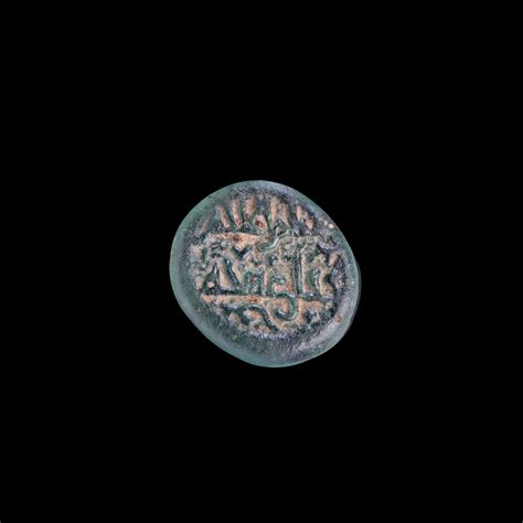 AN EARLY ISLAMIC GLASS WEIGHT OF QUARTER DIRHAM