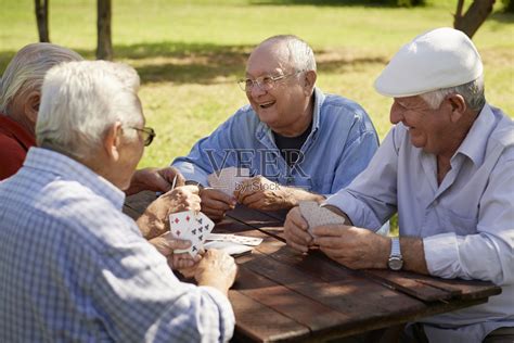 一群老人，微笑着在公园里打牌照片摄影图片_ID:105436041-Veer图库