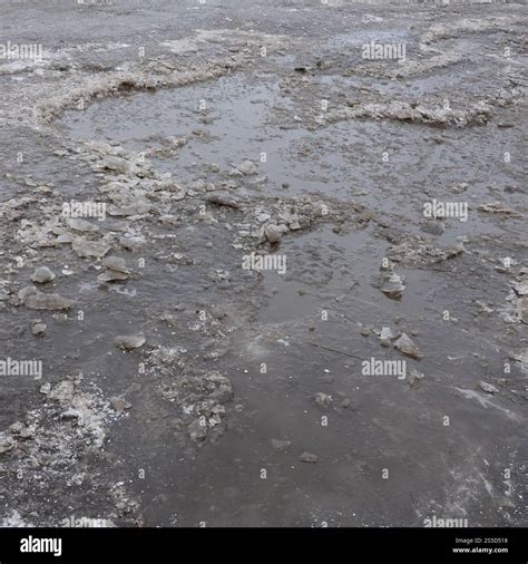 Damaged asphalt road with potholes caused by freezing and thawing ...