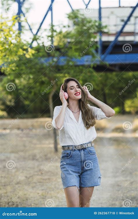 Stylish Spanish Woman Listening To Music with Wireless Headphones in a ...