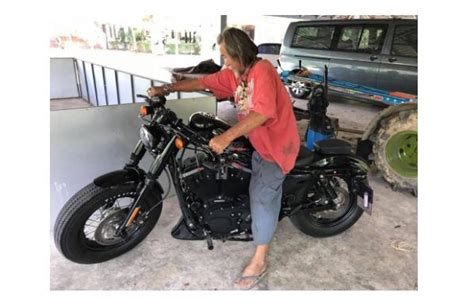 Haggardly old man pulls out wads of notes for Harley Davidson bike ...