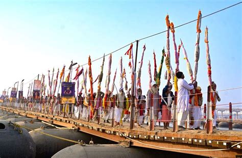 Sadhus (holy men) take out a religious procession on a pontoon bridge ...