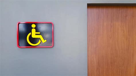 Toilet sign on gray or grey wall for reserved disable people use this washroom only with copy ...