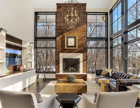 Modern Living Room Features Towering Fireplace Among Floor to Ceiling ...