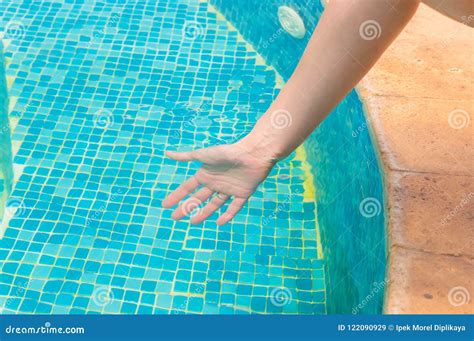 Young Girl Testing the Swimming Pool Temperature with Her Hand in the ...
