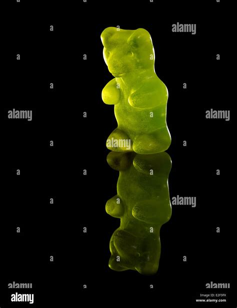 green translucent gummy bear in black reflective back Stock Photo - Alamy