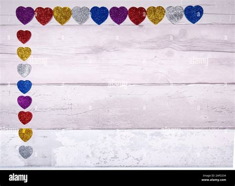 Hearts with glitter of all colors on a background of old wooden planks ...