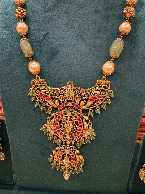 A regal pearl, gold, and emerald beaded necklace, completed with a mag ...
