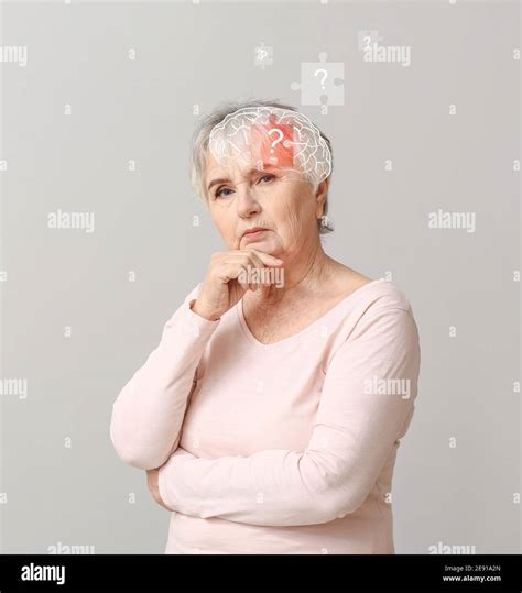 Elderly woman suffering from mental disability on grey background Stock ...