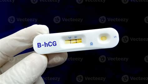 Glove hand hold a device of Beta hCG rapid screening test, show ...