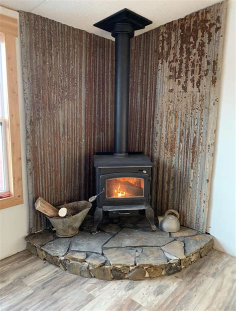 a wood burning stove sitting inside of a living room next to a wooden ...