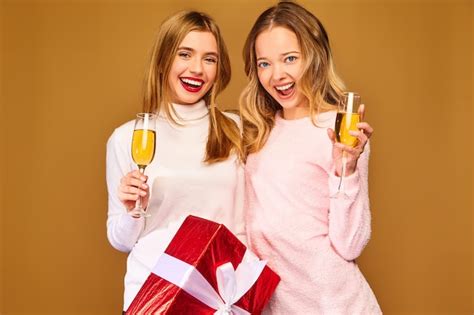 Models with big gift box drinking champagne in glasses celebrating new ...